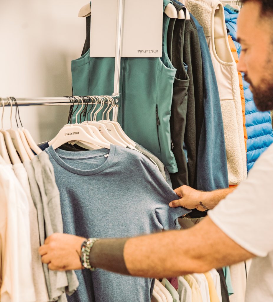 Textilauswahl im Showroom – blaues T-Shirt an Kleiderständer.